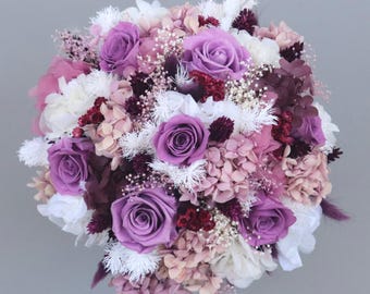 Dreamlike bridal bouquet of dried flowers in violet, lilac, shades of purple, cream and white with stabilized roses