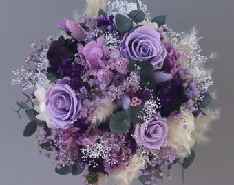 Small bridal bouquet of dried flowers in violet, lilac, purple tones, cream and white with stabilized roses