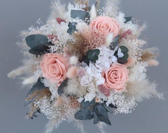 Bridal bouquet made of dried flowers in pastel shades with preserved roses