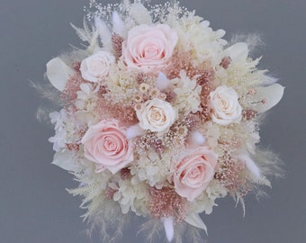 Fantastic bridal bouquet of dried flowers in pastel tones with stabilized roses