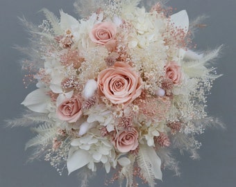 Small bridal bouquet of dried flowers in pastel tones with stabilized roses