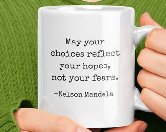 May include: White ceramic mug with a black inspirational quote by Nelson Mandela: "May your choices reflect your hopes, not your fears."