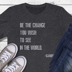 May include: A dark gray t-shirt with the quote "Be the change you wish to see in the world. -Gandhi" printed in white.