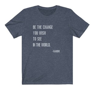 May include: A dark blue t-shirt with a white quote that reads "Be the change you wish to see in the world. -Gandhi".