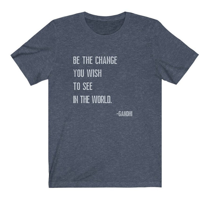 May include: A dark blue t-shirt with a white quote that reads "Be the change you wish to see in the world. -Gandhi".