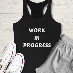May include: Black tank top with white text that reads "WORK IN PROGRESS".