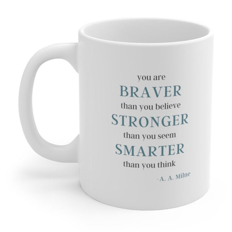 May include: White ceramic mug with a blue quote that reads "You are braver than you believe, stronger than you seem, smarter than you think - A. A. Milne"