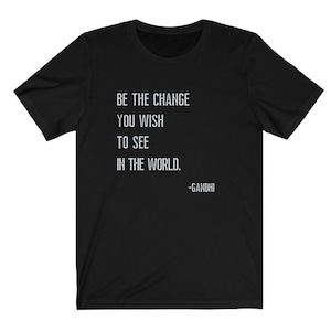 May include: Black t-shirt with white text that reads "Be the change you wish to see in the world. -Gandhi"