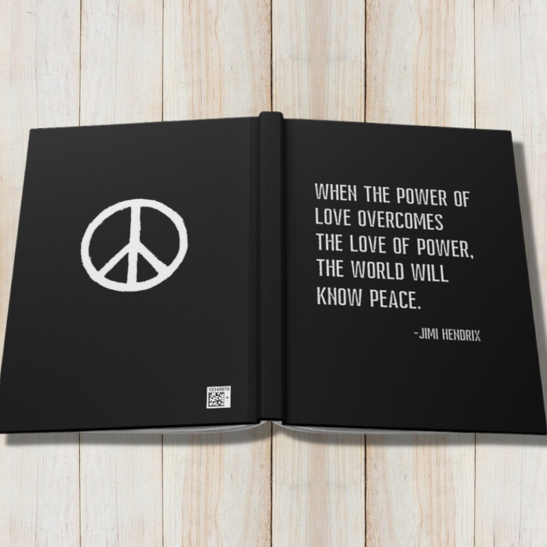 May include: A black book with a white peace sign on the left page and a quote by Jimi Hendrix on the right page. The quote reads: "When the power of love overcomes the love of power, the world will know peace."