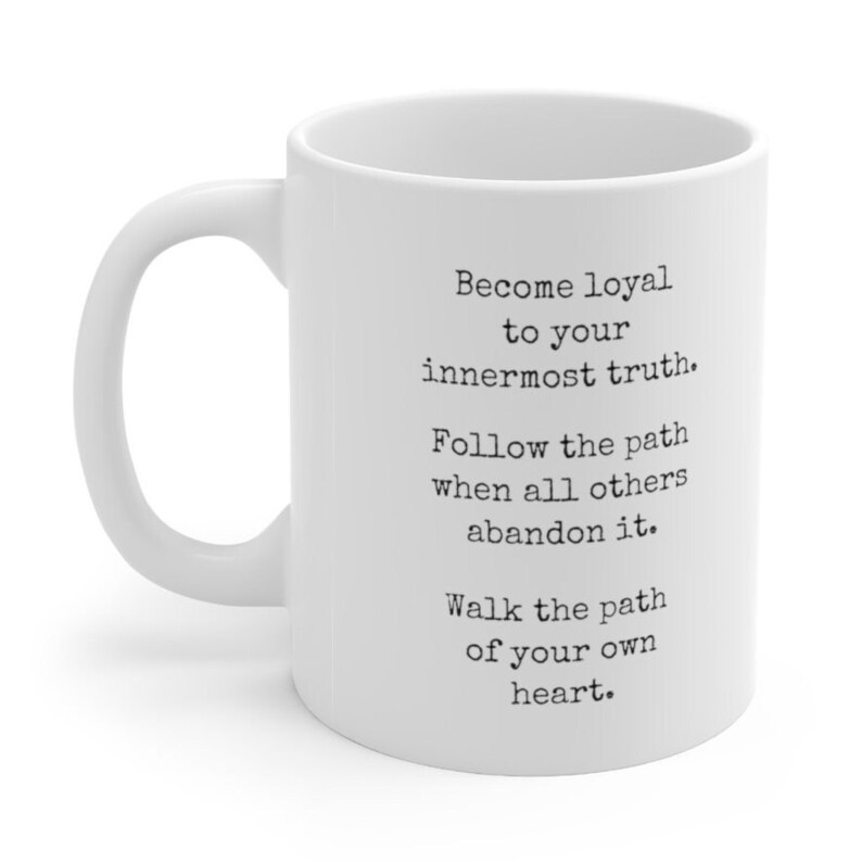 May include: White ceramic mug with a black inspirational quote: "Become loyal to your innermost truth. Follow the path when all others abandon it. Walk the path of your own heart."