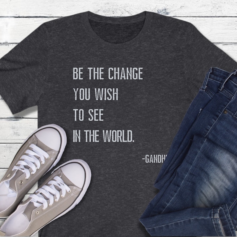 May include: A dark gray t-shirt with the quote "Be the change you wish to see in the world. -Gandhi" printed in white.