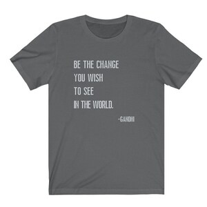 May include: A dark gray t-shirt with the quote "Be the change you wish to see in the world. -Gandhi" printed in white.
