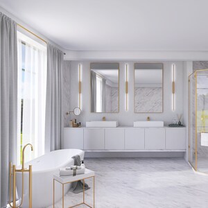 May include: A white bathtub with gold fixtures in a modern bathroom with white marble walls and floors. There are two sinks with gold faucets and mirrors above them. The bathroom also has a glass shower with gold accents.