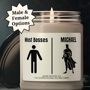 May include: A brown soy wax candle with a white label that reads "Most Bosses" with a stick figure and "MICHAEL" with a superhero figure. The candle is 9 oz and is scented.