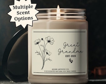 May include: A brown glass candle with a white label that reads "Great Grandma EST. 2024" with a floral design and a pair of footprints. The candle is 9 oz and made with natural soy wax.