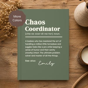 May include: A sage green hardcover book with white text that reads Chaos Coordinator, followed by a dictionary-style definition describing a person who manages many tasks, and the name Emily written in a script font at the bottom.