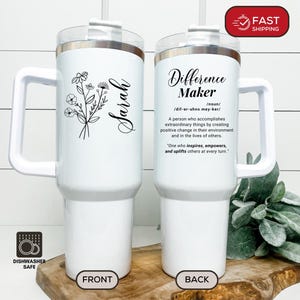 May include: White insulated tumbler with a handle, featuring a floral design and the name "Sarah" on the front. The back of the tumbler has the text "Difference Maker" with a definition. Includes a straw and a "Dishwasher Safe" icon.