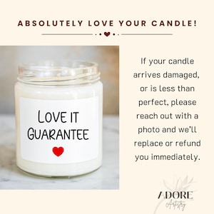 May include: A white candle with a clear glass jar and a white label that says "Love It Guarantee" with a red heart. The candle is on a white surface. The text "Absolutely Love Your Candle!" is at the top of the image. The text "If your candle arrives damaged, or is less than perfect, please reach out with a photo and we'll replace or refund you immediately." is on the right side of the image. The text "ADORE Artstry" is at the bottom of the image.