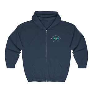 Pu&ograve; includere: Una felpa con cappuccio blu navy con zip, con un'immagine di un occhio bianco e il testo "Che ogni occhio malvagio diventi cieco".