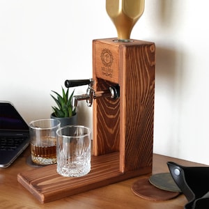a wooden desk with a glass holder and a laptop on it
