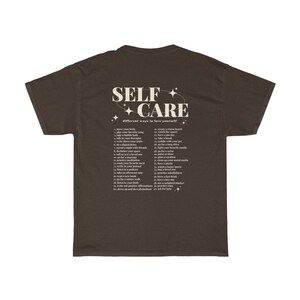 May include: A brown t-shirt with the text "SELF CARE" in white with stars around it. The text "different ways to love yourself" is below the main text. A list of self-care tips is printed below the text.