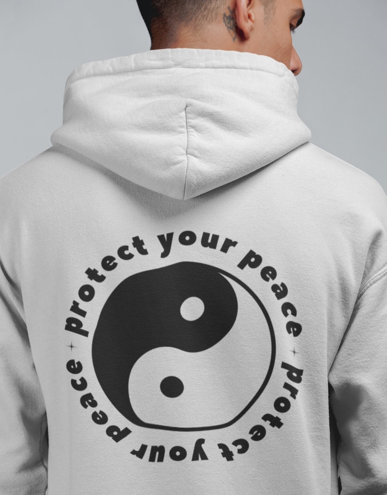 May include: A white hoodie with a black yin yang symbol and the text "Protect your peace + protect your peace" in a circle around it.