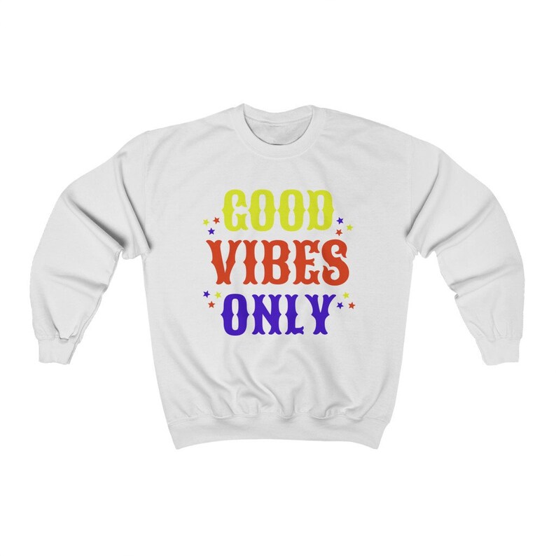Op de afbeelding: Wit sweatshirt met de tekst "GOOD VIBES ONLY" in kleurrijke letters met gele sterren rond de tekst.