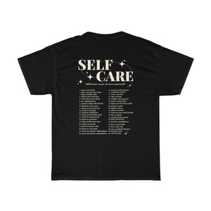 May include: Black t-shirt with white text that reads "SELF CARE different ways to love yourself" and a list of self-care activities.