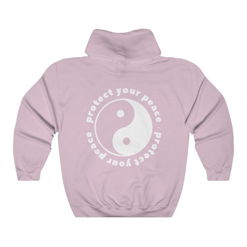May include: A pink hooded sweatshirt with a white yin yang symbol and the text "Protect your peace - protect your peace" in a circle around it.