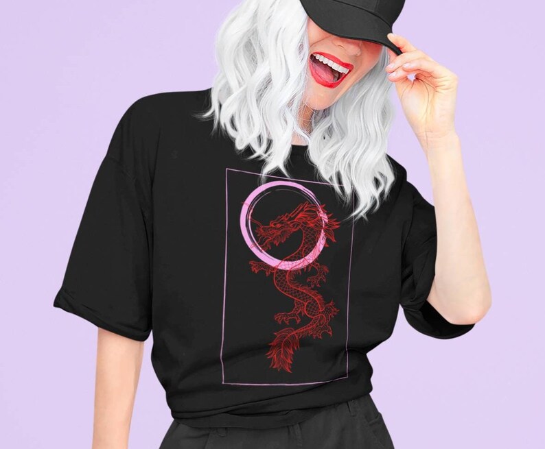 May include: A black t-shirt with a red dragon graphic and a pink circle around it. The dragon is stylized and has a detailed design.