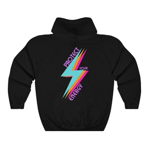 K&ouml;nnte beinhalten: Schwarzer Kapuzenpullover mit einem Grafikdruck eines Blitzes in Pink, Orange und Blau. Der Text "Protect Your Energy" ist auf dem Blitz geschrieben.