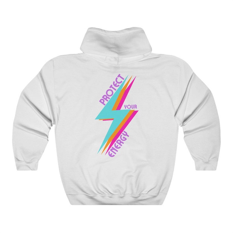 K&ouml;nnte beinhalten: Wei&szlig;er Kapuzenpullover mit einem bunten Blitz-Motiv und dem Text "Sch&uuml;tze deine Energie" in Lila.