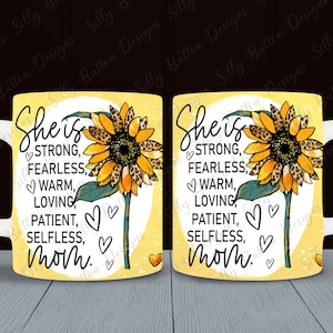 May include: A white ceramic mug with a yellow background featuring a sunflower and the words "She is STRONG, FEARLESS, WARM, LOVING, PATIENT, SELFLESS, Mom." The mug has a white handle.