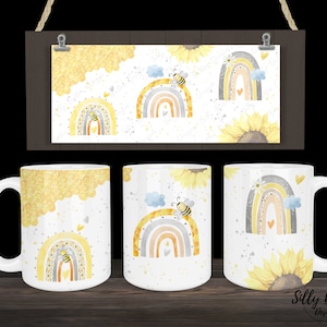 May include: Three white ceramic mugs with a bee and rainbow design. The mugs feature a watercolor style illustration of a rainbow with a bee on top, surrounded by yellow sunflowers and honeycomb patterns.