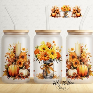 May include: Three frosted glass tumblers with a fall theme. Each tumbler has a different design featuring sunflowers, pumpkins, leaves, and candles. The tumblers have bamboo lids and clear straws.