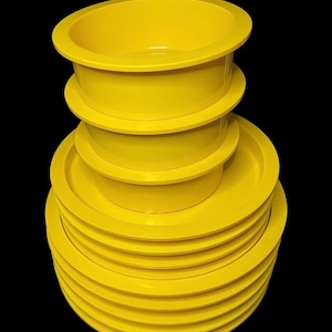 May include: A stack of yellow plastic bowls, with the largest bowl on top and the smallest bowl on the bottom.