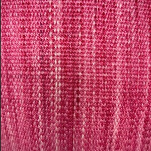 Puede incluir: Primer plano de una tela tejida rosa y blanca con un patr&oacute;n texturizado.