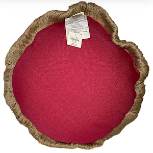 Puede incluir: Una almohada redonda de color rojo con un borde de flecos marrones. La almohada tiene una etiqueta adjunta con el texto "ROUND" y otra informaci&oacute;n.