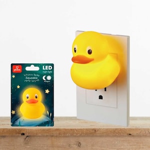 May include: A yellow rubber duck-shaped LED night light plugged into a white wall outlet. The packaging features the Globe brand logo, the text Squeakie, and LED night light, showing the duck illuminated against a dark blue starry background.