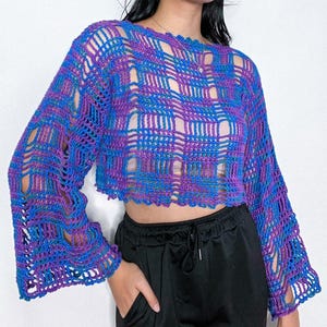 Peut inclure: Un haut en crochet violet et bleu avec un design lâche et ajouré et de longues manches bouffantes.