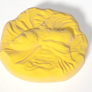 以下が含まれることがあります： 横たわった魚を彫刻した黄色い陶器。尾は丸まっており、魚は水のように見える、質感のある波打つ表面に囲まれている。