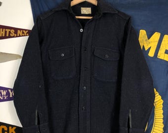 May include: A dark blue long-sleeved shirt with a button-up front and two flap pockets. The shirt has a label that reads "L.L. Bean" and "Maine Hunting Shoes".