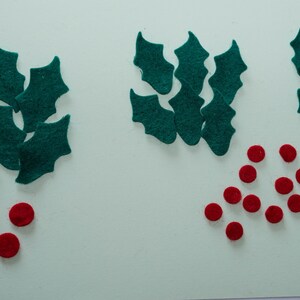 May include: Assortment of felt holly leaves and red felt berries for crafting projects.