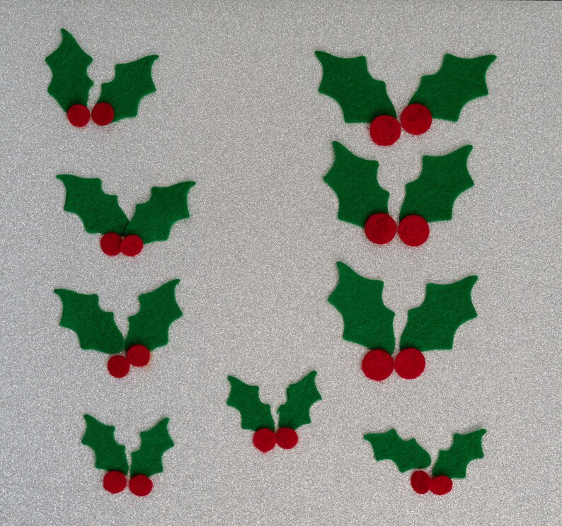 May include: Ten green felt holly leaves with red felt berries. The holly leaves are arranged in pairs with the berries in the center of each pair.