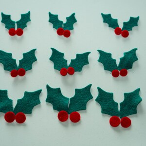 May include: Ten felt holly sprigs with red berries. Each sprig has two green leaves and two red berries.
