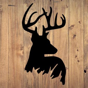 May include: A black silhouette of a deer head with antlers against a woodgrain background.