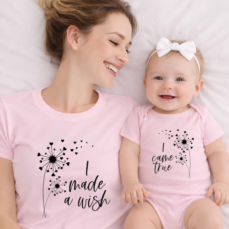 May include: Matching pink t-shirts and onesie with a dandelion design. The adult shirt says "I made a wish" and the baby onesie says "I came true". The dandelion design includes hearts.