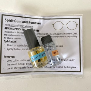 May include: Two small clear glass bottles with black caps containing spirit gum and remover, labeled with blue and orange tape. They are packaged in a clear plastic bag with an instructional card titled Spirit Gum and Remover.