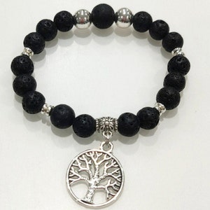 May include: Black lava rock bracelet with a silver tree of life charm. The bracelet is made of small, round beads and has a silver clasp.
