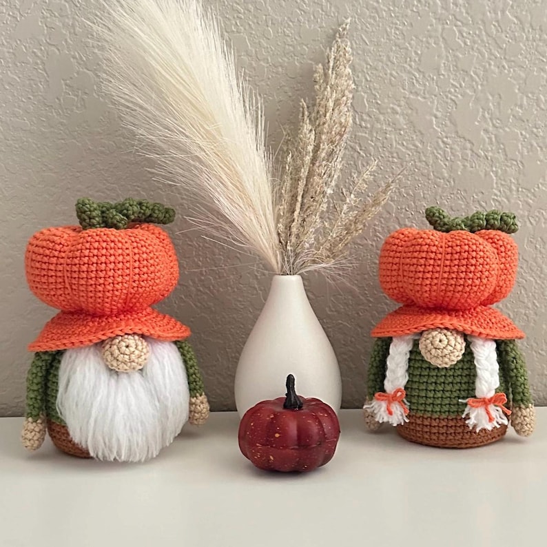 Two crocheted gnomes with orange pumpkin-shaped hats, one with white braided hair and the other with a white beard. Digital PDF download.
